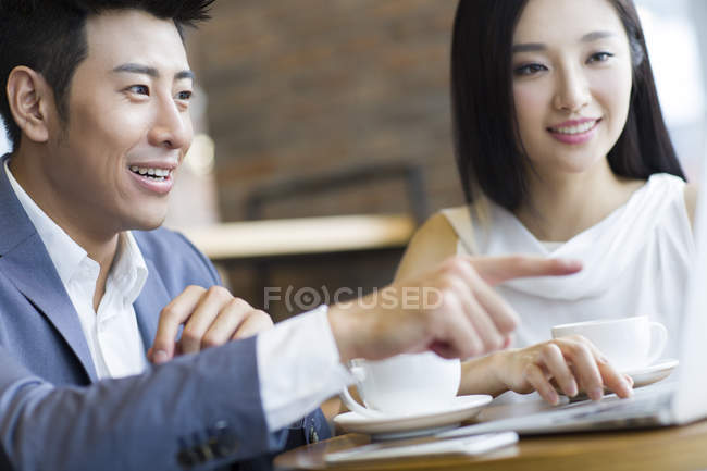 Les gens d'affaires chinois utilisant un ordinateur portable dans un café — Photo de stock
