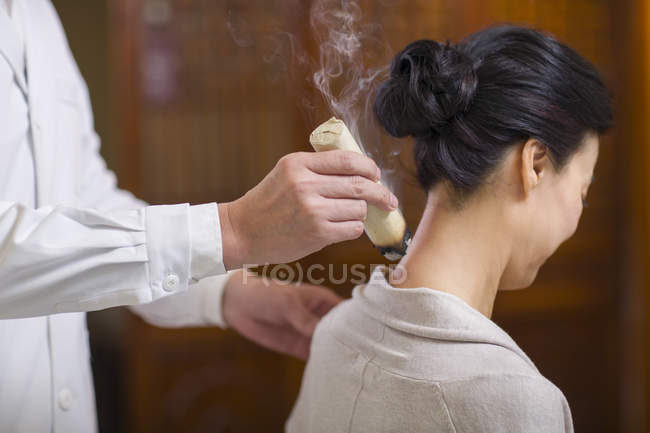 Médico realizando terapia de moxibustión en mujer madura - foto de stock