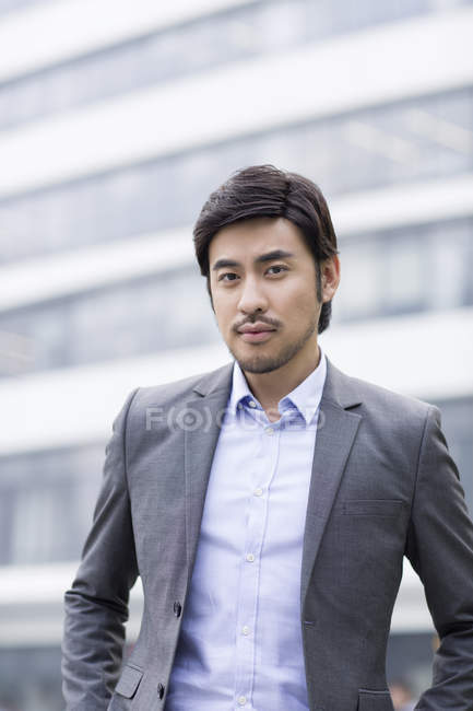 Уверенный китайский бизнесмен стоит на улице — стоковое фото
