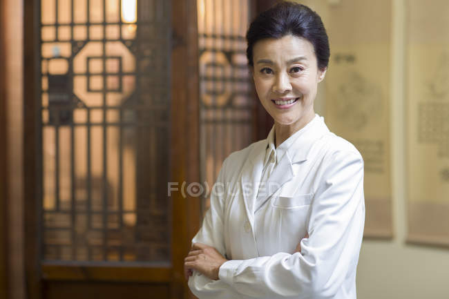 Retrato de médico chinês feminino com os braços dobrados — Fotografia de Stock