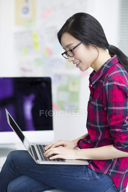 Mulher chinesa usando laptop no escritório — Fotografia de Stock