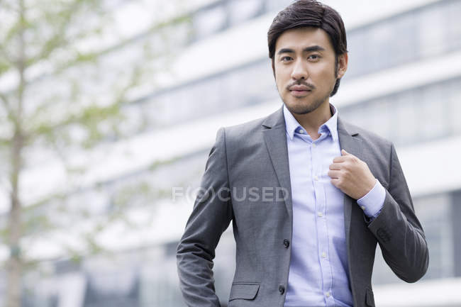 Selbstbewusster chinesischer Geschäftsmann steht auf der Straße — Stockfoto