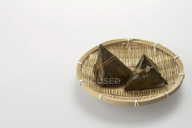 Zongzi in woven bowl isolated on white background — Stock Photo