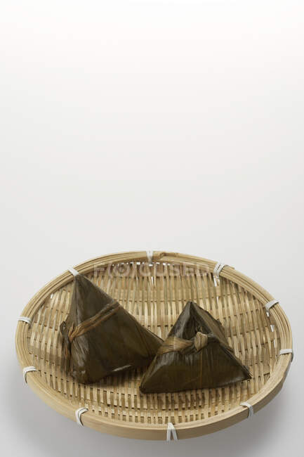 Chino Zongzi en tazón tejido sobre fondo blanco - foto de stock