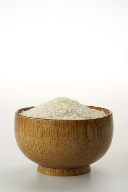 Рис в дерев'яній мисці ізольований на білому фоні — стокове фото