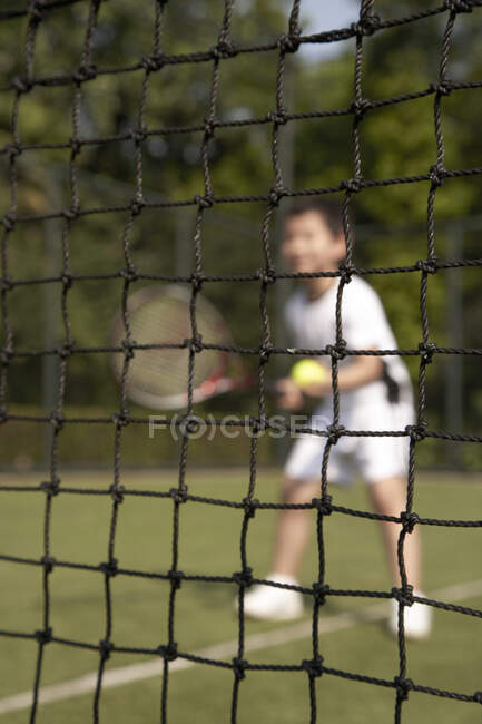 Маленький китайский мальчик играет в теннис — стоковое фото