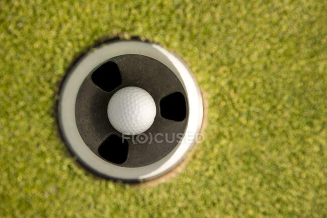 Pelota de golf en el agujero - foto de stock