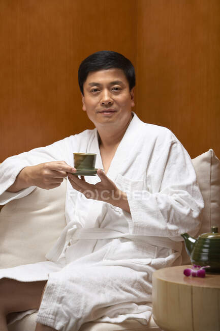 Chinese man drinking tea at a spa — Stock Photo