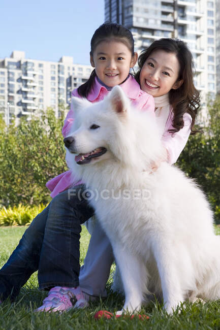 Китайская мать и дочь с семейной собакой — стоковое фото