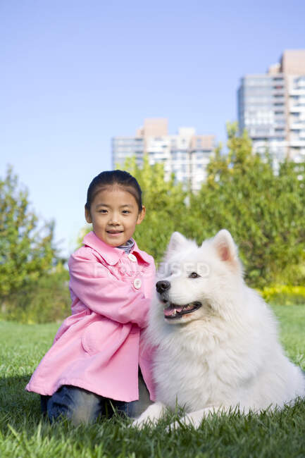 Joven chica china y su perro - foto de stock