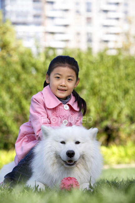 Menina chinesa jovem e seu cão — Fotografia de Stock