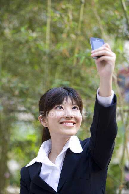 Китаянка делает селфи на старом телефоне — стоковое фото