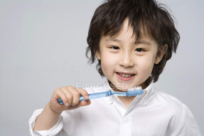 Pequeno menino chinês feliz com escova de dentes — Fotografia de Stock