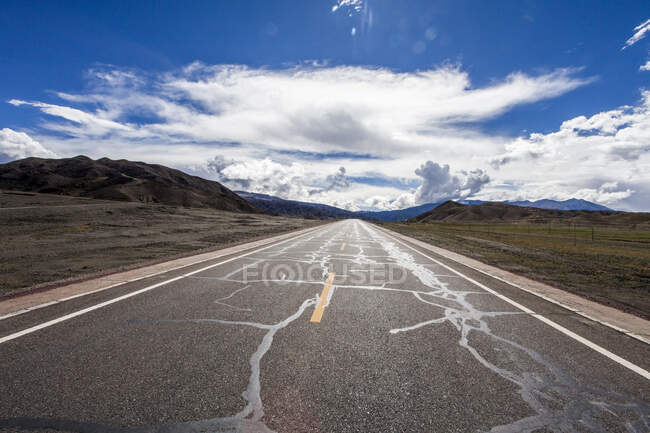 Estrada com vista montanhas e céu nublado, Tibete, China — Fotografia de Stock