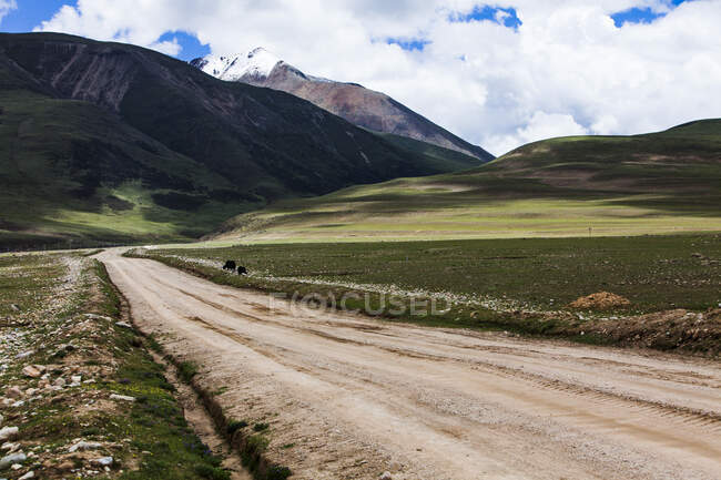 Дорога з гірським видом і хмарним небом, Тибет, Китай — стокове фото