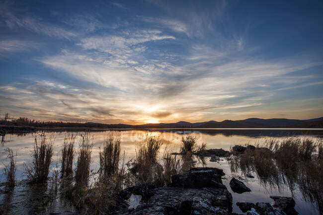 Lago con riflesso del cielo al tramonto e montagne — Foto stock