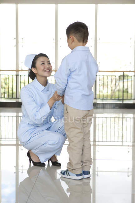 Infirmière chinoise parler à jeune garçon — Photo de stock