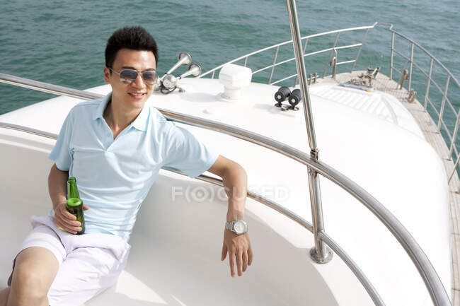Uomo cinese rilassante su uno yacht — Foto stock