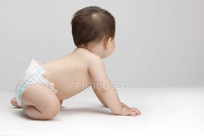 Estudio de un lindo bebé chino mirando hacia otro lado - foto de stock