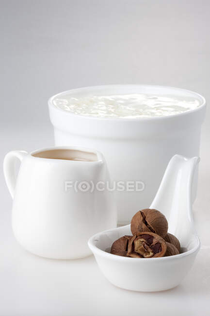 Mel, iogurte e nozes em recipientes cerâmicos — Fotografia de Stock
