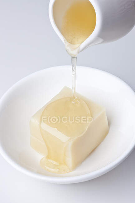 Miele versando da brocca su dessert di soia — Foto stock