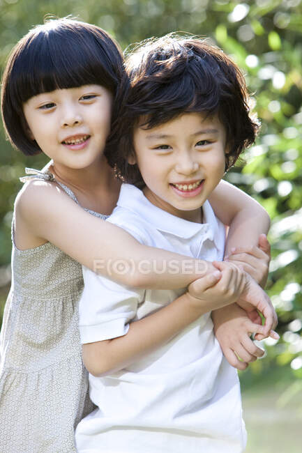 Lindos niños chinos que se divierten en el jardín - foto de stock