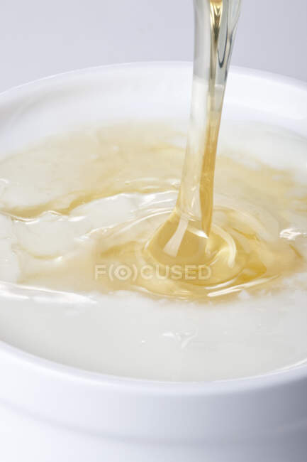 Close Up shot of Honey Pouring Into Yogurt — Stock Photo