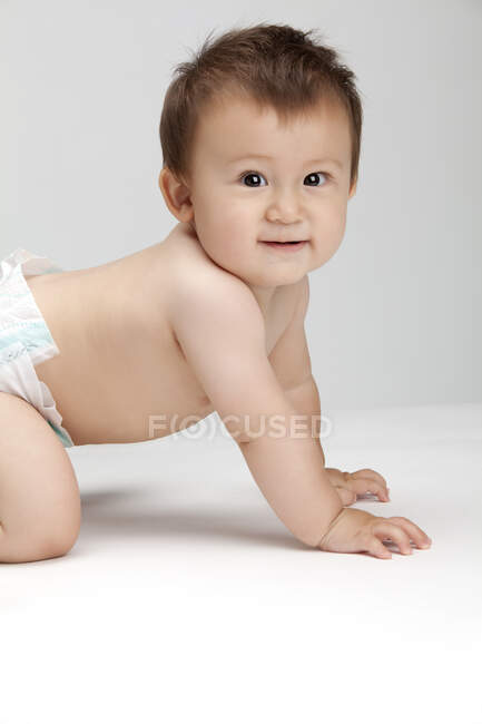 Studio shot of a cute Chinese baby boy crawling — Stock Photo