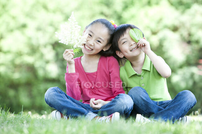 Joven chica china y chico sentado juntos - foto de stock