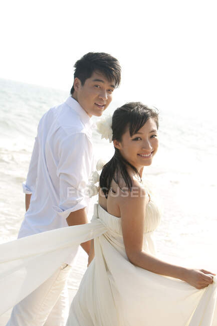 Glückliches chinesisches Brautpaar am Strand — Stockfoto