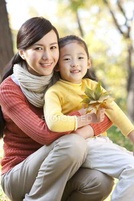Mère et fille chinoises ramassant des feuilles — Photo de stock