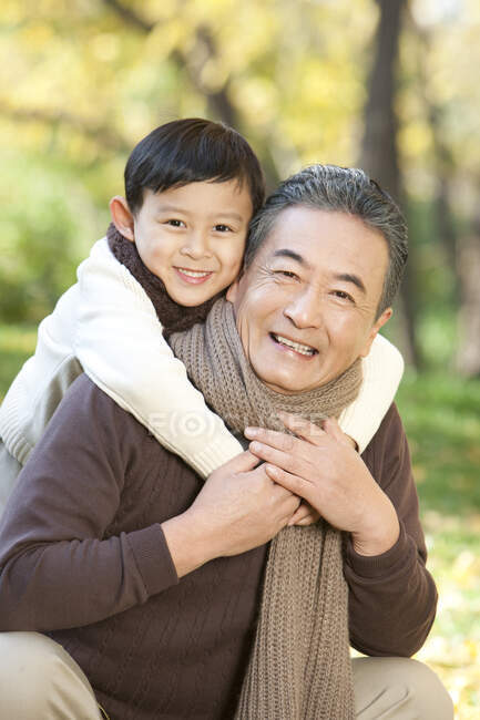 Китайский мальчик обнимает своего дедушку — стоковое фото