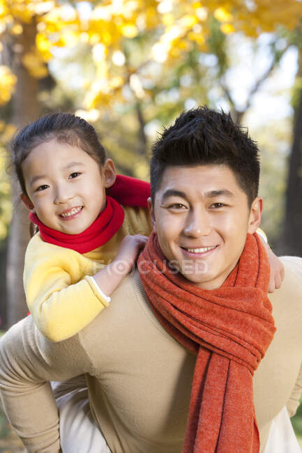 Chinese father and daughter in a park in autumn — Stock Photo