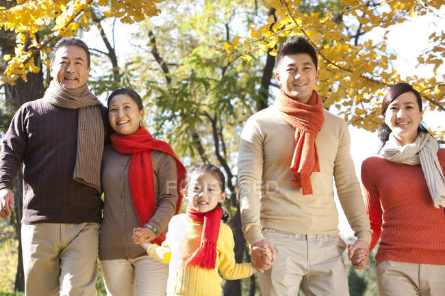 Familia china caminando en un parque en otoño - foto de stock