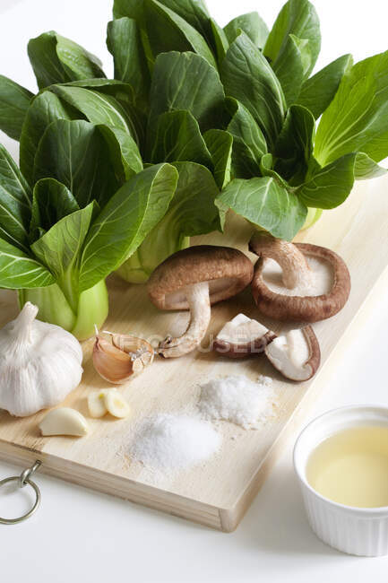 Garlic, Mushrooms and Bok Choy on cutting board — Stock Photo