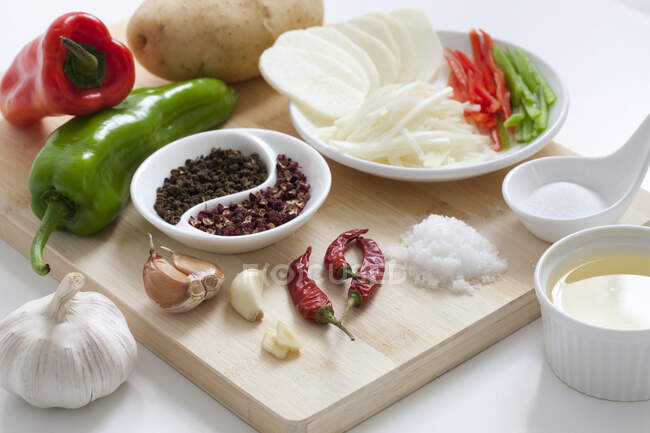 Various ingredients on wooden board, whole and chopped vegetables with spices — Stock Photo