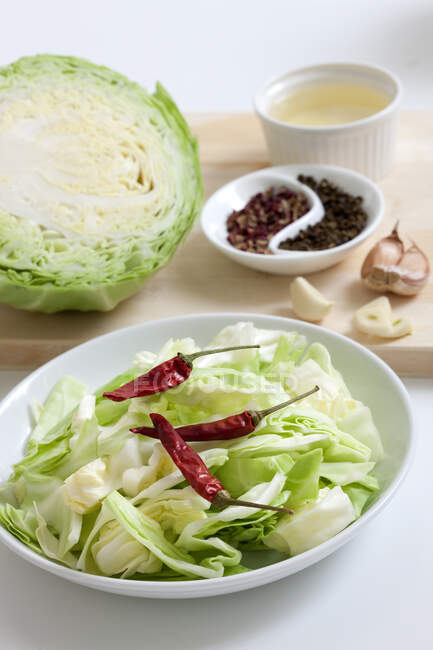 Cabbage salad with dried chili peppers and ingredients on background — Stock Photo