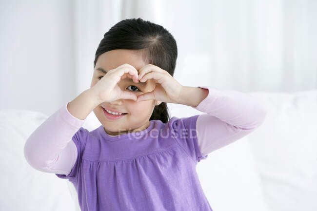 Chinese girl hands in heart shape — Stock Photo