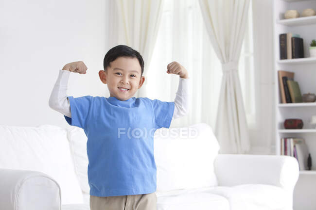 Chinese boy flexing muscles — Stock Photo