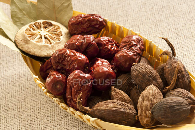 Dried fruit and bay leaves in small wicker basket — Stock Photo