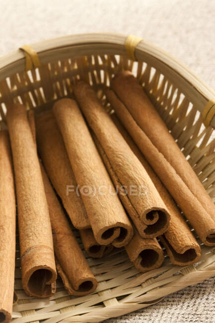 Cinnamon sticks in small wicker basket — Stock Photo