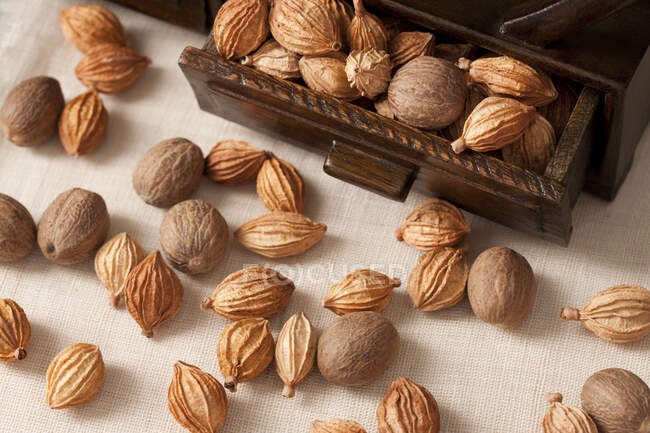 Орехи и специи в деревянном гробу и на столе — стоковое фото