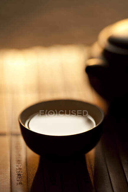 Чашка чаю і горщик на бамбуковому килимку, крупним планом — стокове фото