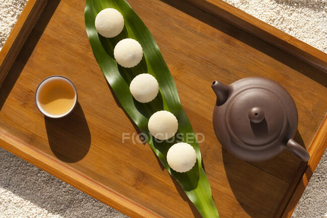 Tea set of pot and cup and dim sum on green leaf — Stock Photo