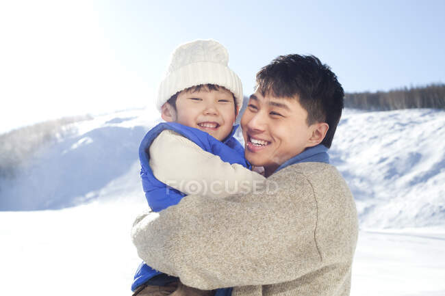 Père chinois jouant avec son fils dans la neige — Photo de stock