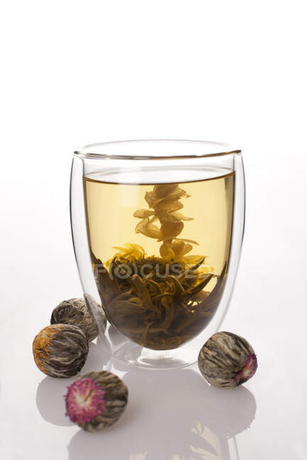 Китайский травяной чай в стекле и рядом изолированы на белом фоне — стоковое фото