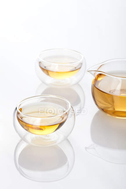 Glass tea set with pot and tea in cups isolated on white background — Stock Photo