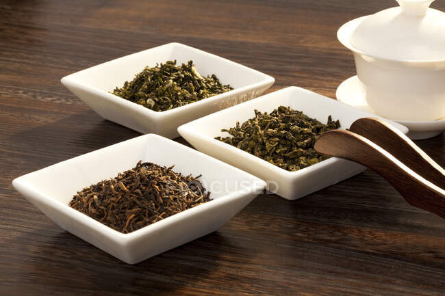 Чай в керамических чашках на деревянной поверхности — стоковое фото