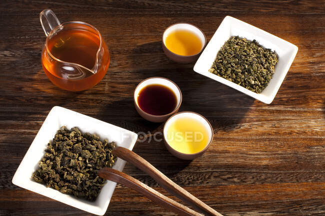 Chá em tigelas e conjunto de chá na mesa de madeira — Fotografia de Stock