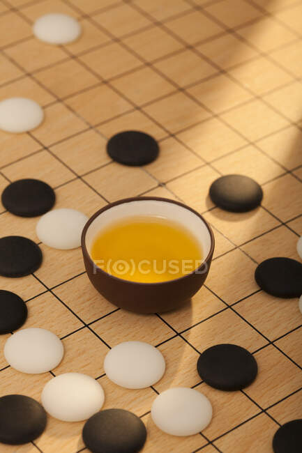 Tea and Chinese go game on board — Stock Photo